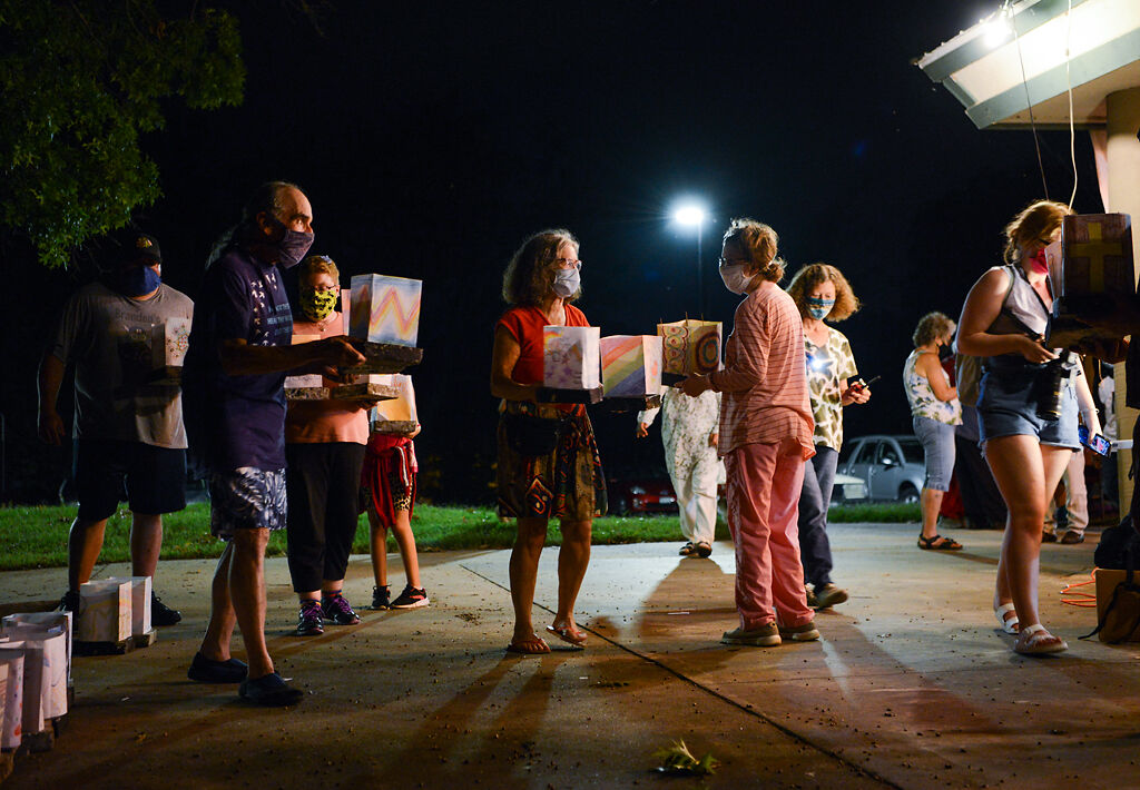 Mark Haim passes out lanterns to participants